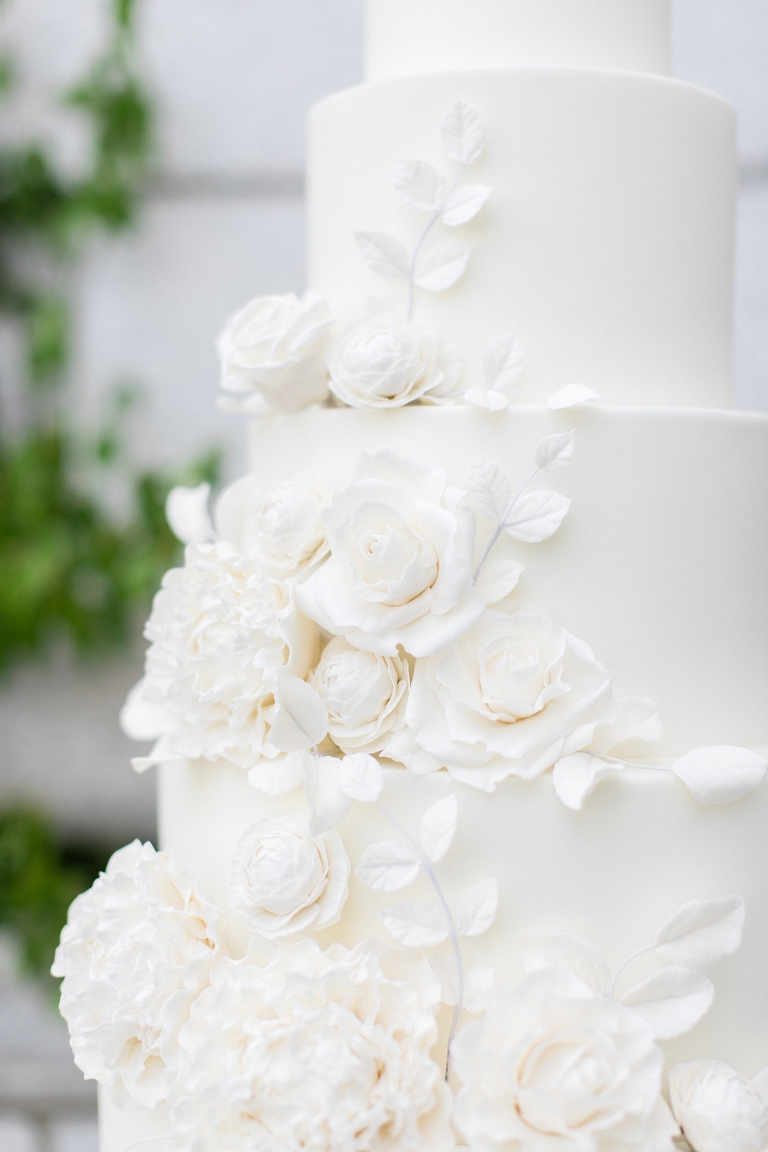 All white wedding cake by Flour and Flourish. White wedding cake flowers made out of sugar.