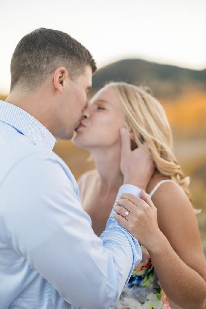 Couple kissing in golden aspen trees during a fall engagement session at Bonanza Flat near Park City, Utah